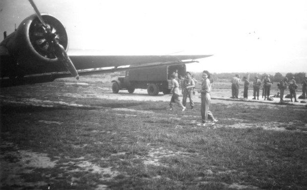 Sous l' aile d'un JU 52 le camion de distribution des parachutes.Avec le Lieutenant Roger PHILIPPON deux jeunes femmes qui semblent être des convoyeuses de l' air