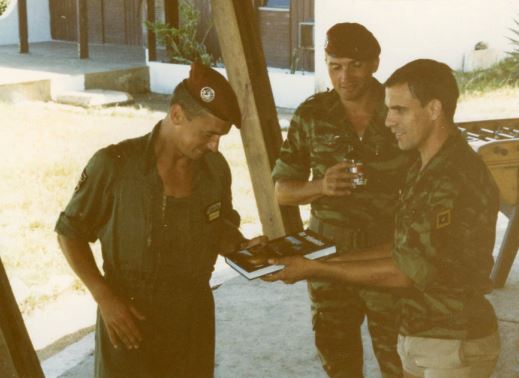 Le Lieutenant René FERRON reçoit un livre sur La REUNION en cadeau des mains du Sergent José VINUES sous le regard du Sergent-Chef EBERT-WALKENS