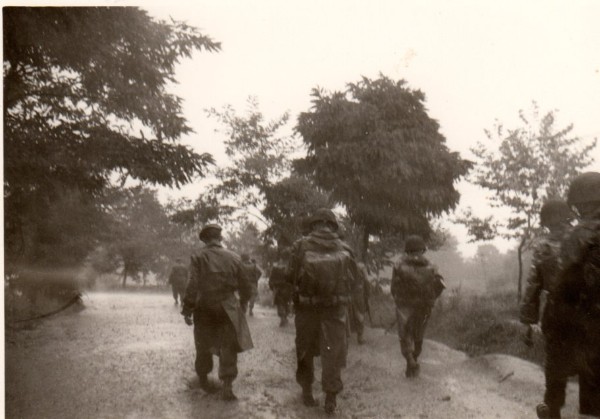 .Les parachutistes sont casqués ,revètus de l'imperméable troupe ,qui ne mérite guère son qualificatif d'imperméable .