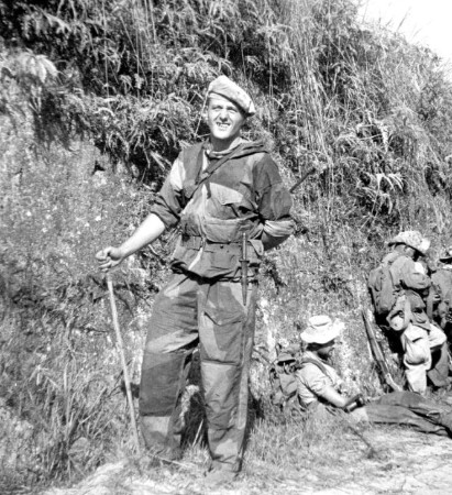  Courte halte . Le Lieutenant Roger PHILIPPON est assis Les autres personnages sont restés debout .L'officier de face qui s' appuie sur un baton porte une tenue Anglaise "windproof " non modifiée La veste a ses quatre poche et sa capuche .Le pantalon a sa poche sur le devant de la jambe gauche  et ses pattelettes de serrage sur les chevilles .Le beret de type gurka en toile claire est sans doute de fabrication locale .