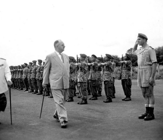 Détachement du I° Para LAO passé en revue par une autorité territoriale civile .Le détachement porte une veste camouflée US et un pantalon de te tenue de saut type CHAVATTE en fabrication locale d' Extrème Orient 