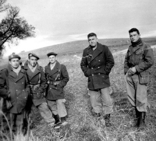 Le Capitaine Roger PHILIPPON avec les parachutistes de la Section de Commandement se réchauffent au soleil levant après une nuit à la belle étoile