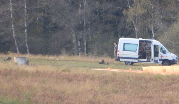 Le radio , attendant le prochain largage est assis contre une buse  et lit tranquillement à proximité d'une batte à feu.