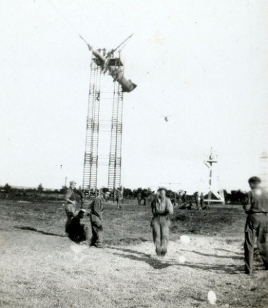 On voit nettement la construction en bois moins élevée qu'une tour de saut; L' arrivée s'effectue dans une fosse à sable sommaire. L'arrivée au sol était généralement beaucoup plus rapide que lors d'un saut en parachute