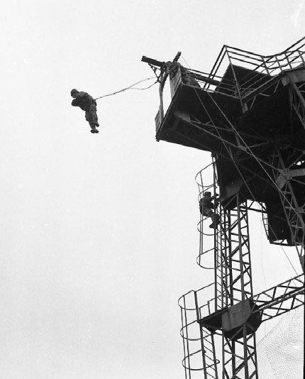 Vue d'en bas un saut en position réglementaire . Un parachutiste grimpe sur la plateforme 