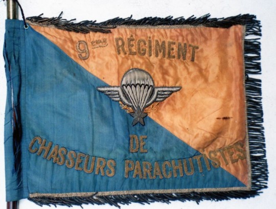 frangé d' or il est parfaitement conforme au "1° type" Tranché sur ses deux faces de JAUNE ( parties flottantes ) et de BLEU roi (à la hampe) il porte à l' avers un Brevet de Parachutiste et l'inscription 9° Régiment de Chasseurs Parachutistes brodés en cannetille d'or .Au revers , surmontant l'insigne au naturel du 9° R.C.P. l'inscription brodée en cannetille 3° compagnie .La 192° Promotion de Saint Cyr  ( 2005-2008 ) porte le nom de Capitaine BEAUMONT ."   