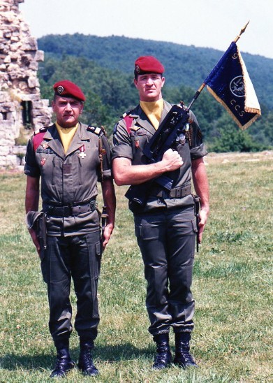   " Le Capitaine BERSILLON Commandant de Compagnie  avec le Sergent Chef GERVAIS Porte Fanion de la C.C.S. Les foulards d'identification sont  CARMIN indicatif de la  C.C.S. "