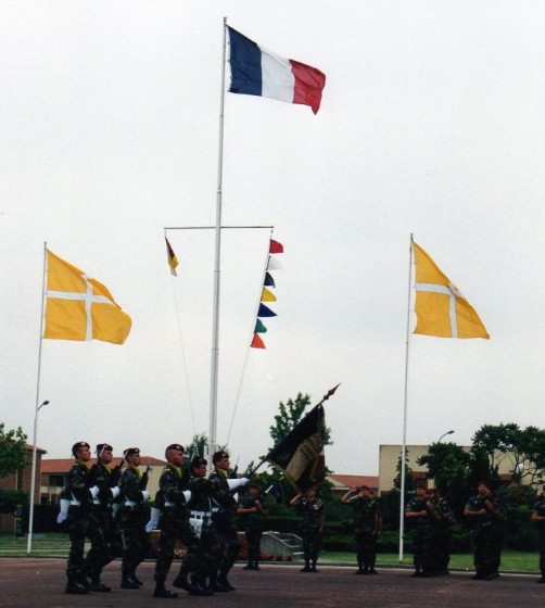 Pavoisement à l'occasion d'une prise d' armes .Au centre Pavillon National. A gauche Flamme de présence du chef de Corps A droite flammes des Compagnies  ROUGE : CCS, BLANC: 1°Cie , NOIR: 2° Cie, JAUNE :3° Cie, BLEU:  ?         VERT : CA , ORANGE C.B.I. ou 11° Cie 