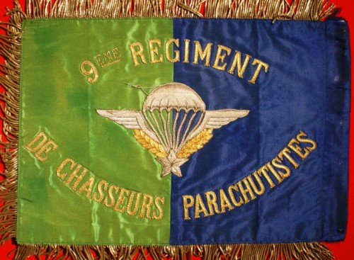 Au revers un Brevet de Parachutiste  au naturel encadré de l'inscription "9° Régiment de Chasseurs Parachtistes " brodée en fil d'or .L'interieur des suspentes laisse apparaitre les couleurs BLEU et VERT ."  