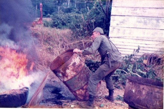 Le Capitaine Paul LEGRAS  parait vouloir éteindre un feu d' herbes sèches provoqué par l'incinération de documents