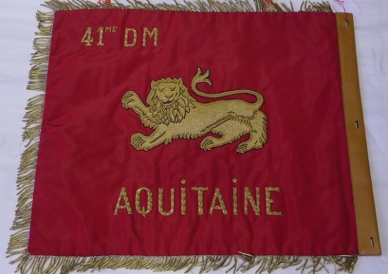 ROUGE sur les deux faces , frangé sur les trois cotés flottants il est brodé d'or .Pourquoi ROUGE ? Probablement pour restituer  le blason de la Province (au revers léopard d' AQUITAINE ) Mais à l' avers il aurait fallu afficher la couleur de la 20°compagnie  )