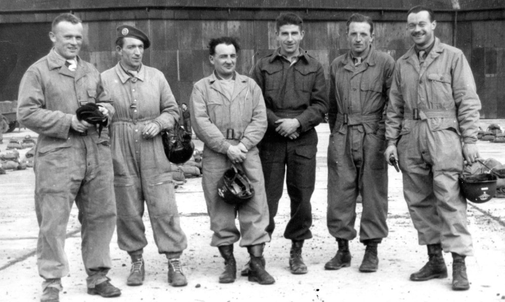  le Lieutenant Roger PHILIPPON pose au milieu d'un groupe de ce qui parait être des cadres du CETAP .Il porte une tenue française neuve en drap du modèle 1944 Les autres portent des combinaisons de saut de deux types différents Deux Lieutenant ont peint grade et brevet d'Infanterie de l' Air sur leurs casques US