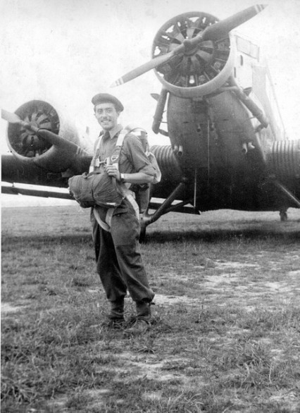 L' homme souriant , en beret, a perçu un parachute T 5 dont toutes les sangles sont de couleur claire .Il a une veste de toile très légère (type U.S. ?) et un pantalon de drap Français modèle 1944 dont le bas est pris dans des guètrons de cuir (ou de toile ?)