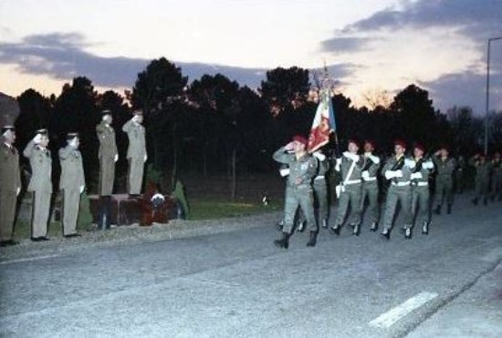 Le Colonel JP VOLA  suivi du Drapeau du 1°RCP sous un ciel menaçant