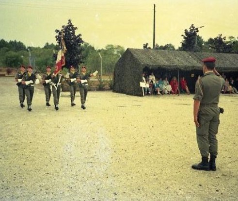 Le Colonel JP VOLA accueille de Drapeau du 1° RCP auquel les Honneurs sont rendus (Sonnerie Au DRAPEAU Refrain de la MARSEILLAISE) La garde du Drapeau porte les "gants à crispin" attributs spécifiques de cette fonction Au fond,à droite, sous un couloir de tentes modèle 56 à pans relevés, les familles assistent à la cérémonie"