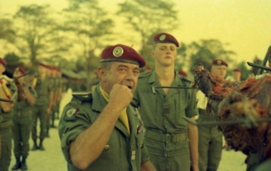 Le Lieutenant Colonel P.de LOUSTAL se prete de bonne grace à son role de goûteur ,en vue de déterminer quel est le meilleur mouton !!