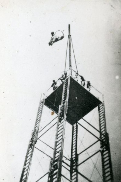 Tour de saut d'arrivée.  Au bout de la potence un cadre suspendu qui descend par gravité selon le poids du parachutiste . Un contrepoids doublé (peut être) d'un système de freinage permet de contrôler la vitesse de descente . 