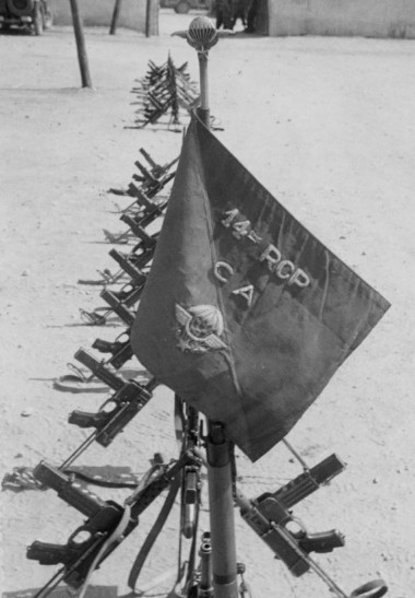 La photo en noir et blanc présente l' avers du Fanion au premier type, sans franges, sur fond de faisceaux de P.M. Mat 49. 